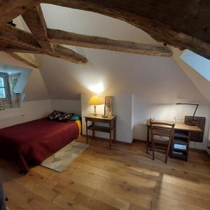 a bedroom with a bed and a desk and a table at La Firmière - Maison de maître - Famille et amis in Omméel