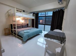 a bedroom with a bunk bed and a table and chairs at 168 Chiangmai Guesthouse in Chiang Mai