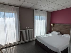 a bedroom with a large bed and large windows at Hotel de la Gare Brest in Brest