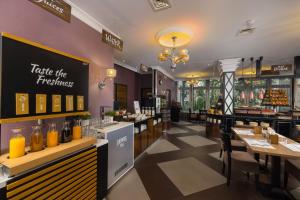 a restaurant with a bar with a counter and tables at Carlton Hotel Buda Castle in Budapest