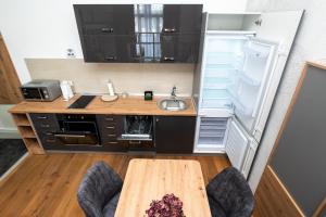 a kitchen with a sink and an open refrigerator at Mountain Magic Bjelašnica in Bjelašnica