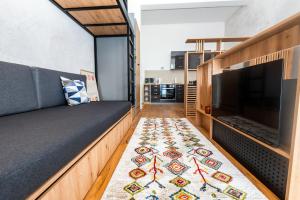a room with a couch and a tv and a rug at Mountain Magic Bjelašnica in Bjelašnica