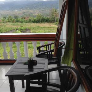 a table and chairs on a balcony with a view at Hotel Dupa in Lovina
