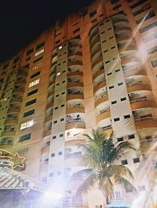 a tall building with a palm tree in front of it at Thermas place 406 in Caldas Novas
