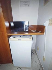a microwave sitting on top of a refrigerator at Thermas place 406 in Caldas Novas