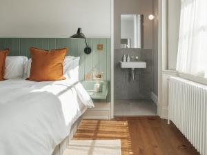 Un dormitorio con una cama y un baño con lavabo. en Constantine House, en Tamworth