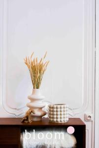 a vase on a table with a plant in it at Le Saint Georges Nancy Stanislas in Nancy