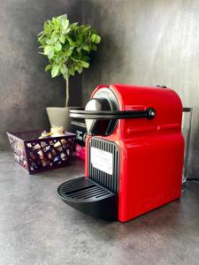 a red toaster sitting on a counter next to a plant at Nancy ARTEM Thermal F2 tout équipé in Nancy