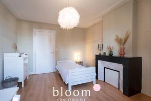 sypialnia z łóżkiem, kominkiem i żyrandolem w obiekcie Nancy centre 3 chambres à 2 pas de la gare w Nancy