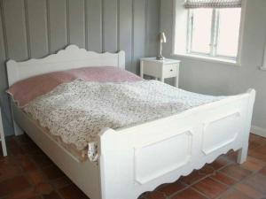 - un lit blanc dans une chambre avec fenêtre dans l'établissement Föhrhaus, Einzelhaus, Knickrehm, à Oldsum