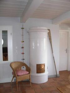 - un salon avec une cheminée et une chaise dans l'établissement Föhrhaus, Einzelhaus, Knickrehm, à Oldsum