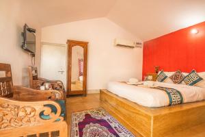 ein Schlafzimmer mit einem Kingsize-Bett und einem Stuhl in der Unterkunft Royal Jaisalmer Resort with Swimming Pool in Jaisalmer