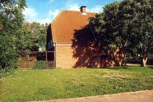 una casa con un albero di fronte a un cortile di Austernfischer, Reihenhaus Guatingwai 12 FH 2 a Goting