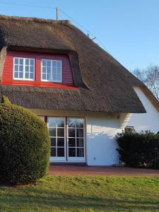 een huis met rieten dak bij Hochstieg 32, Gonska, Haushälfte in Nieblum