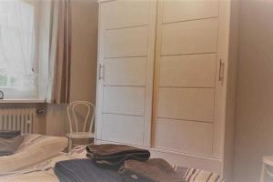 een slaapkamer met een grote witte kast naast een bed bij Hochstieg 36, Feld, Hausteil in Nieblum