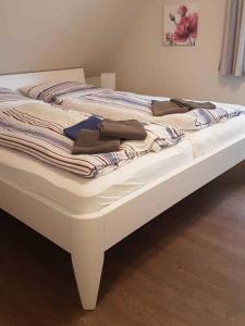 een wit bed met handdoeken erop bij Hochstieg 36, Feld, Hausteil in Nieblum +3 foto's