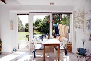 a room with a table and chairs and a window at Strandhaus mit Kaminofen Bungalow in Goting
