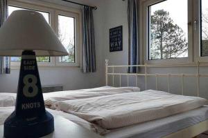 a bedroom with two beds and a lamp on a table at Strandhaus mit Kaminofen Bungalow in Goting +2 photos