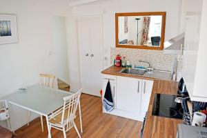 a kitchen with a table and a sink and a counter at Central LDN Southwark 1bdr flat in London