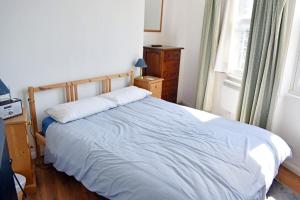 a bedroom with a bed and a dresser and a window at Central LDN Southwark 1bdr flat in London