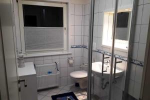 GotingにあるHaus Antje FW Strandlebenのトイレ、洗面台、窓のあるバスルーム +5枚の写真