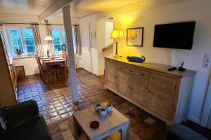 a living room with a flat screen tv on the wall at Skriiwers Hüüs, Hausteil in Alkersum