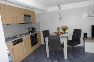 a kitchen with a table and chairs and a kitchen with a sink at Whg Osterheide, Osterheideweg 1 in Nieblum