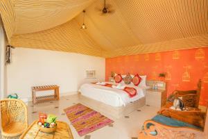ein Schlafzimmer mit einem Bett, einer Couch und einem Tisch in der Unterkunft Royal Jaisalmer Resort with Swimming Pool in Jaisalmer