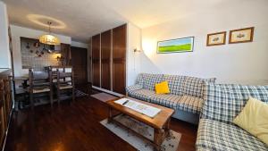 un salon avec un canapé et une table dans l'établissement Hostdomus - Violet Apartment, à Sestrières