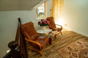 a living room with two chairs and a table with flowers at Vila Zona Centrală in Zalău