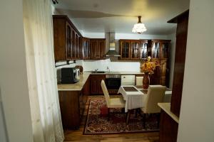 a kitchen with wooden cabinets and a table with chairs at Vila Zona Centrală in Zalău +9 photos