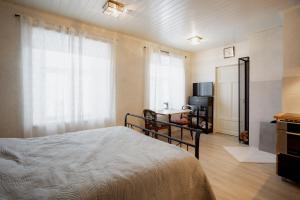 a bedroom with a bed and a television and a window at Von Aghte Small Studio in Kuressaare