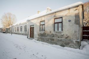 an old building in the snow on a snowy street at Von Aghte Small Studio in Kuressaare