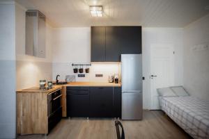 a kitchen with black cabinets and a refrigerator at Von Aghte Small Studio in Kuressaare