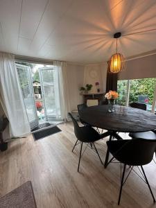 a dining room with a table and chairs in a room at Ruim, mooi en modern huisje met een heerlijke tuin in Baarle-Nassau