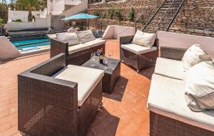 Un patio con sillas y mesas de mimbre junto a una piscina. en Lovely Home In San Juan De Los Terreros, en San Juan de los Terreros