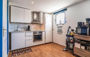 Una cocina con gabinetes blancos y un horno de estufa. en Lovely Home In San Juan De Los Terreros, en San Juan de los Terreros