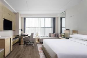 A bed or beds in a room at Shanghai Marriott Hotel Kangqiao