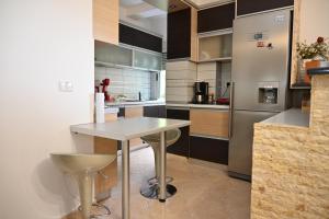 a kitchen with a table and a refrigerator at Roza’s Appartment in Durrës