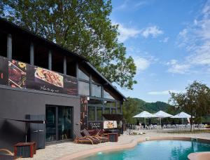 a building with a pool in front of a restaurant at Blissful Resort - Valea Doftanei in Teşila