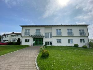 a large white house with a green lawn at Schönstattzentrum Aulendorf in Aulendorf