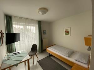a bedroom with a bed and a desk and a window at Schönstattzentrum Aulendorf in Aulendorf +18 photos