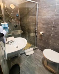a bathroom with a toilet and a sink and a shower at Treestyle Deluxe Rooms in Budapest +25 photos