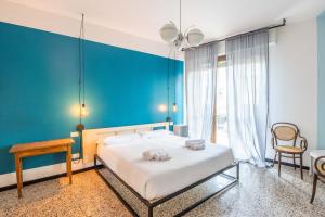 a bedroom with a large bed with a blue wall at Le stanze in Fiera, Bologna by Short Holidays in Bologna