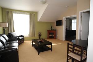 a living room with a couch and a table at Hotel La Porte de la Matawinie -Hôtel Matha in Saint-Jean-de-Matha