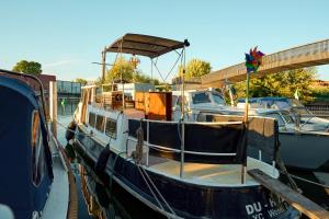 een blauwe en witte boot is aangemeerd bij een dok bij Gemütliches Wohnschiff in Brandenburg an der Havel +3 foto's
