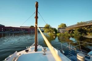 een boot is aangemeerd in het water bij een brug bij Gemütliches Wohnschiff in Brandenburg an der Havel