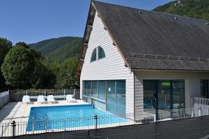 une maison avec une piscine à côté d'un bâtiment dans l'établissement Arreauxygene Duplex 7-9pers, à Arreau 12 autres photos