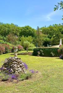 a garden with a statue on a pile of rocks at Mas du Murier in Correns