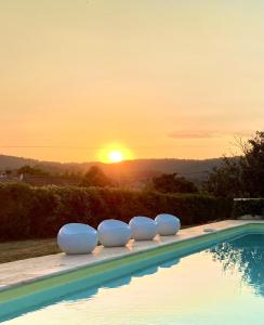 a swimming pool with a sunset in the background at Mas du Murier in Correns +21 photos